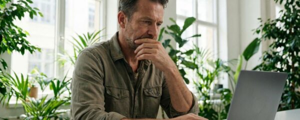 Entrepreneur consultant un site internet sur ordinateur portable dans un bureau moderne